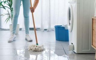 Women mopping water off floor after washing machine flood
